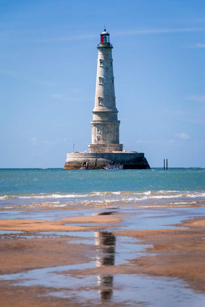 Phare sur la mer, ciel bleu.