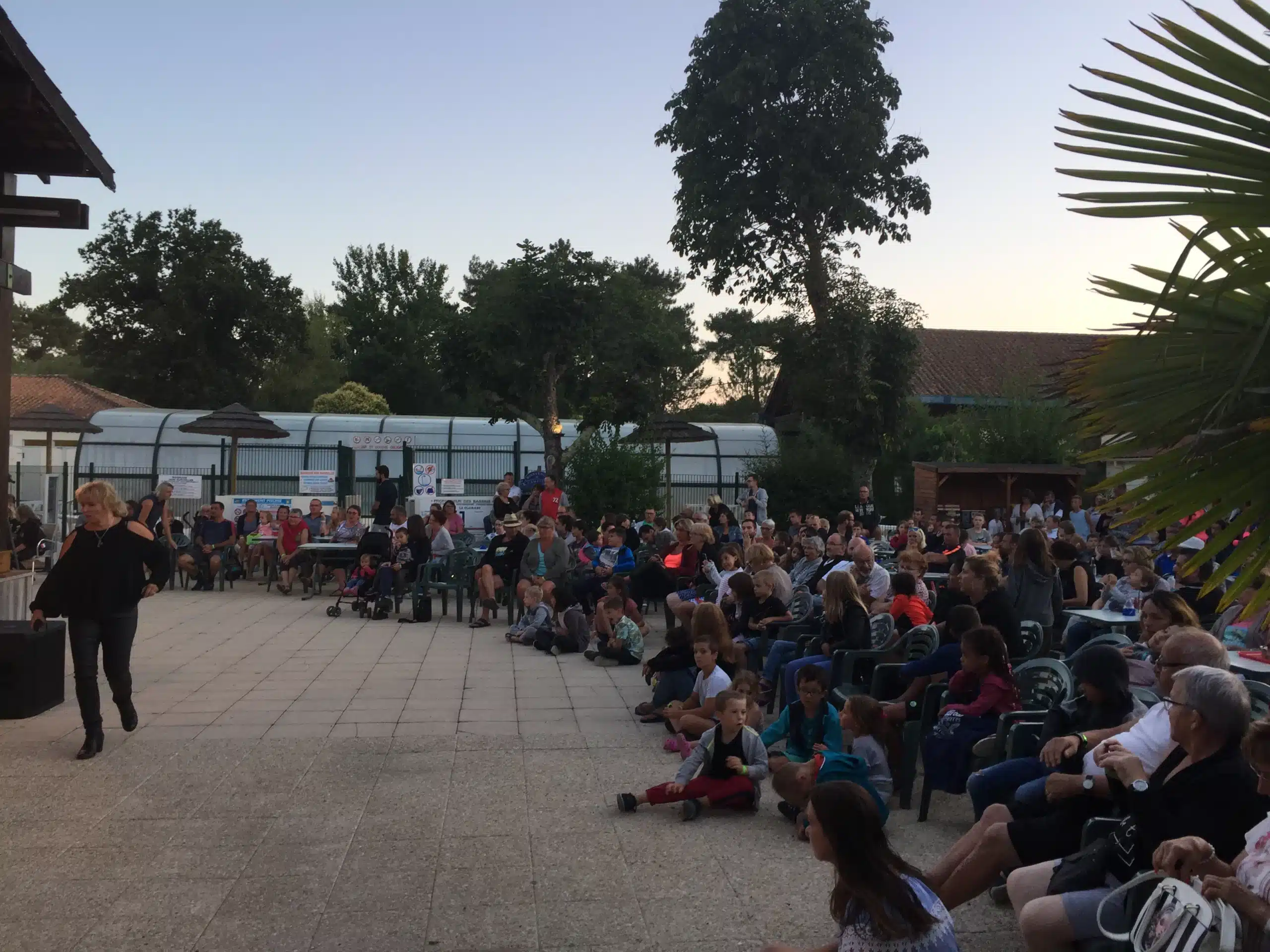 Gruppe von Personen, die in der Abenddämmerung im Freien sitzen.
