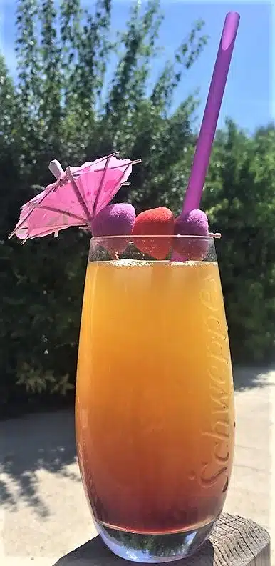 Fruitcocktail met parasol en paars rietje.
