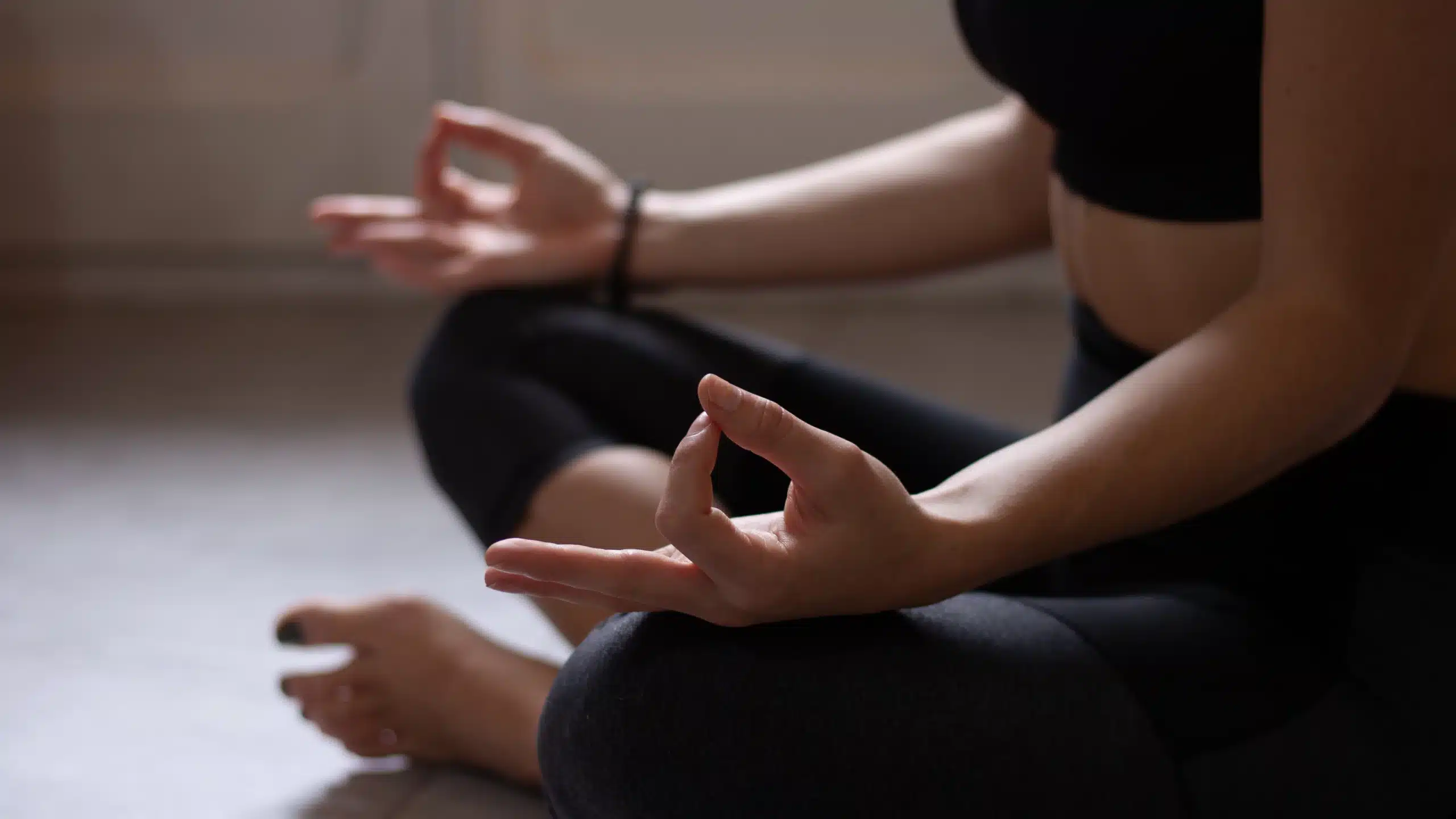 Personne méditant en position de lotus intérieurement.