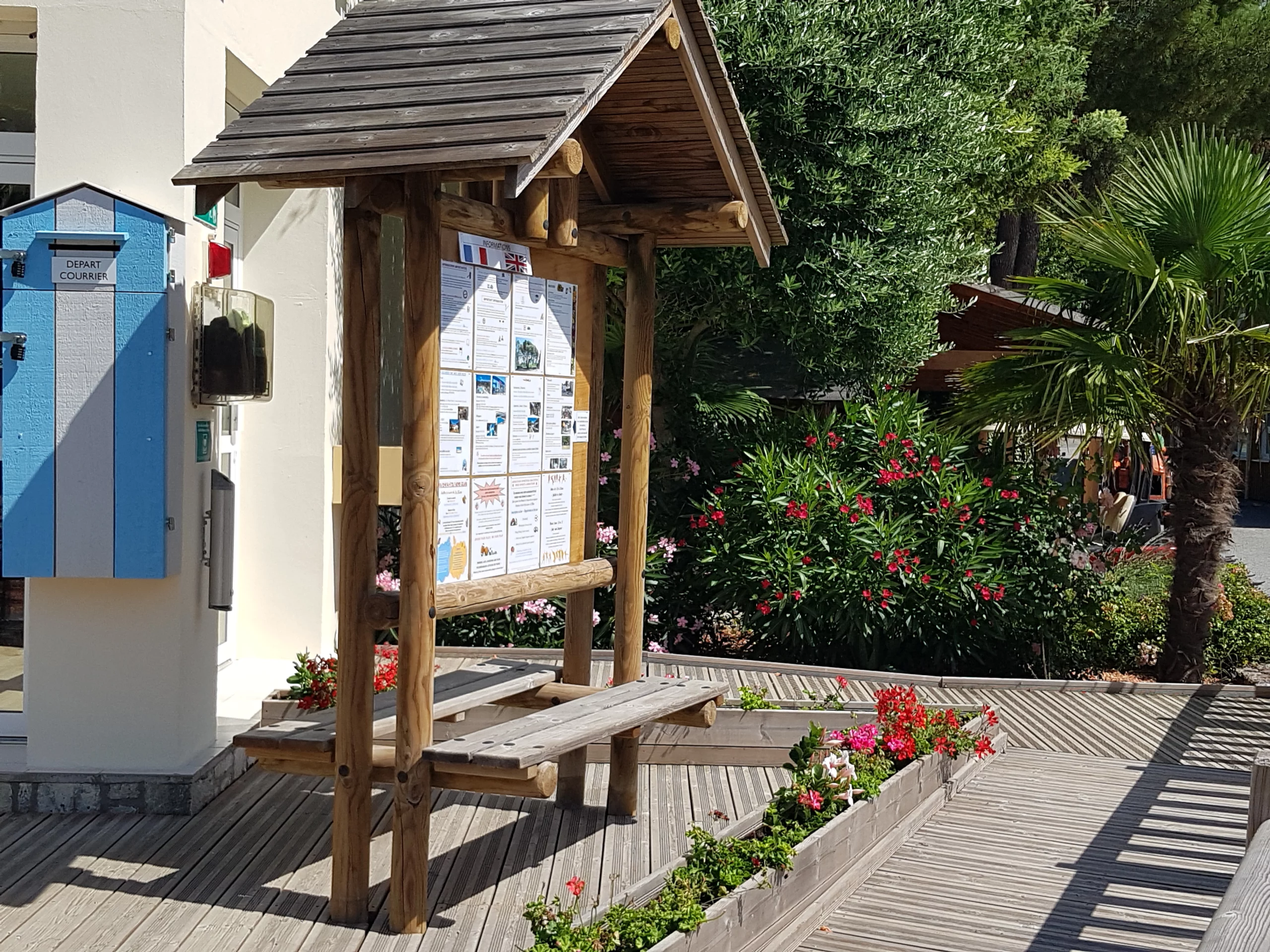 Tableau d'affichage en bois près de boîtes aux lettres.