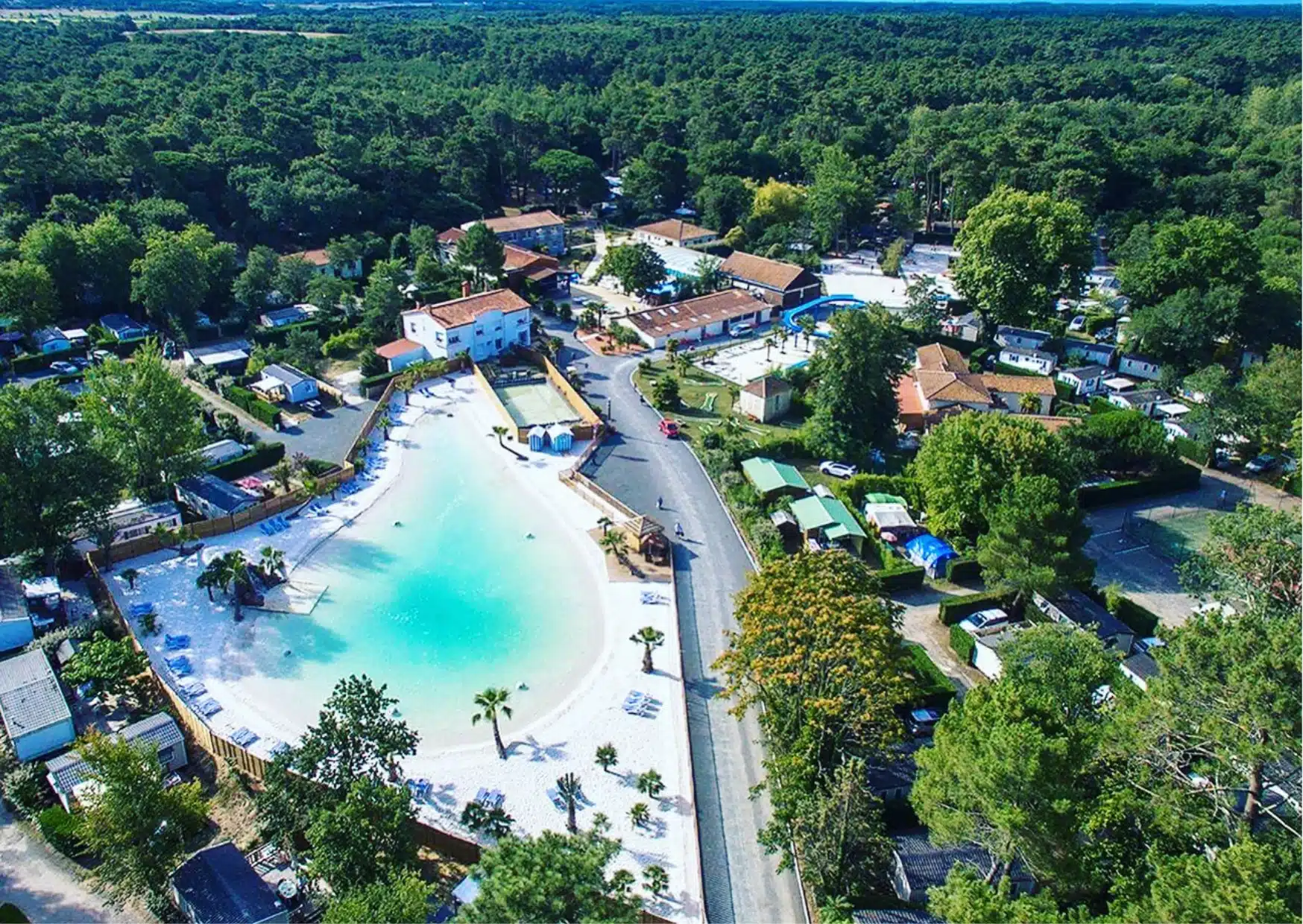 Vue aérienne camping avec piscine et arbres.