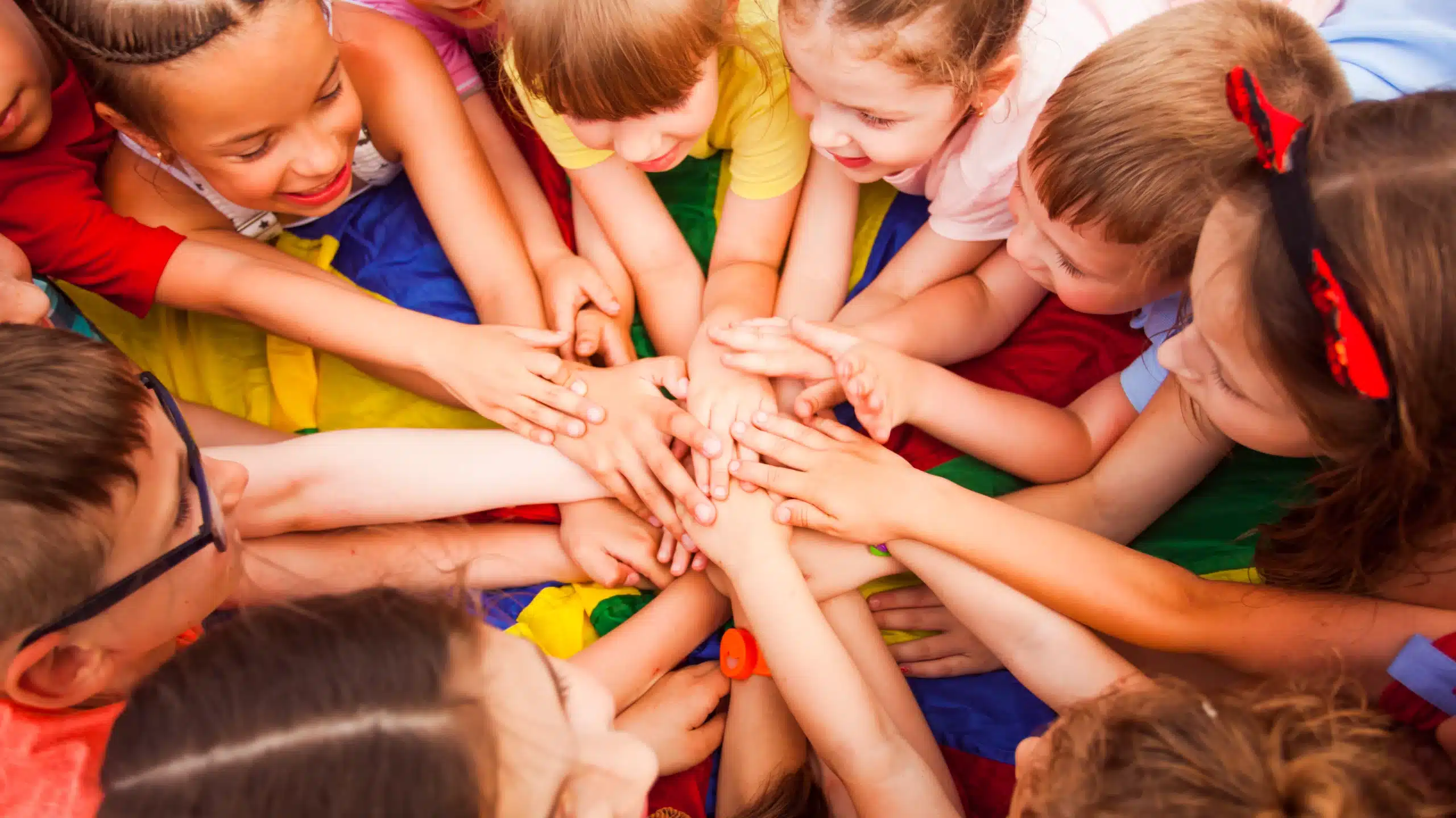 Enfants unis, mains ensemble en cercle coloré.