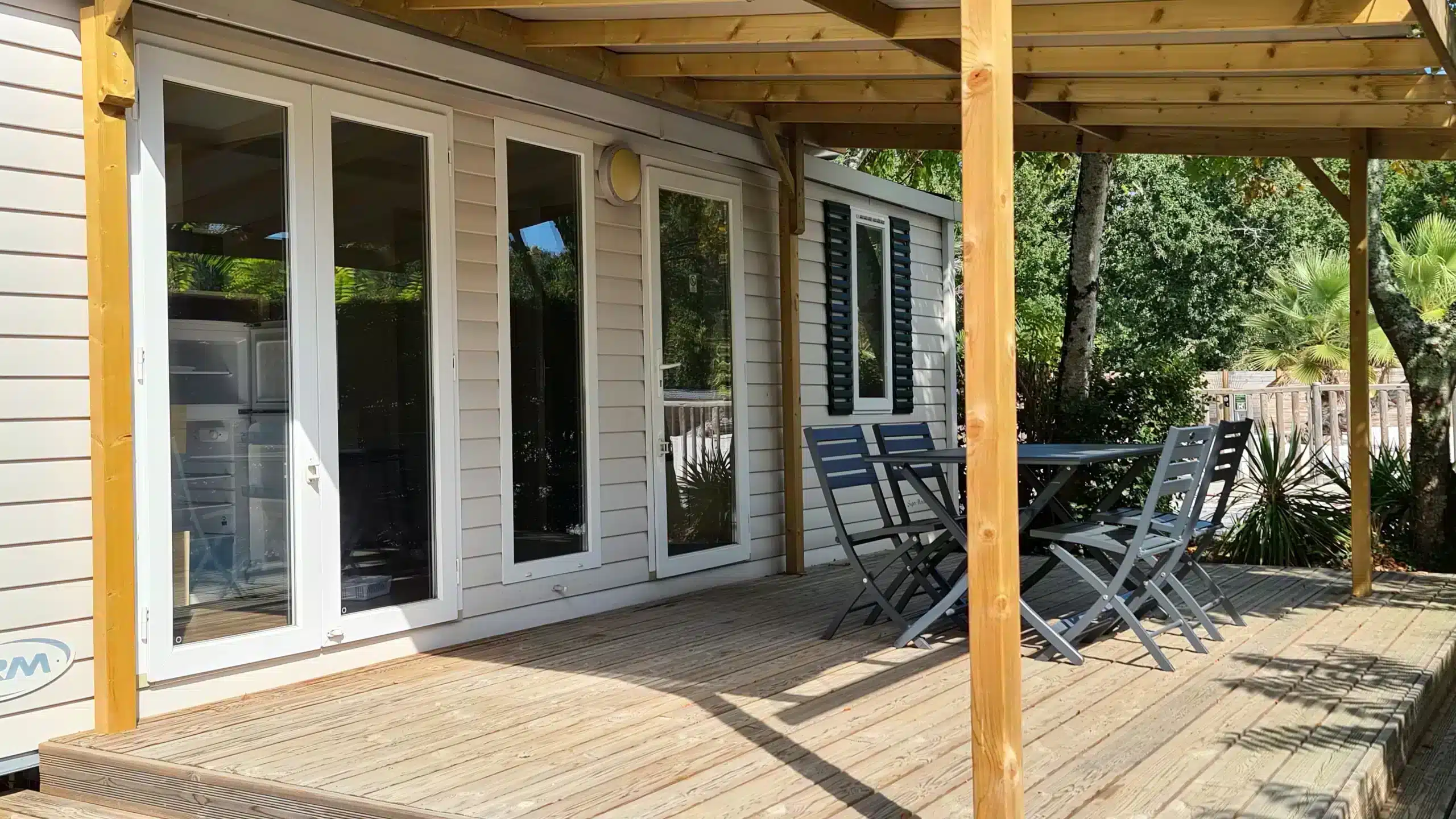 Terrasse en bois avec chaises et table extérieure.