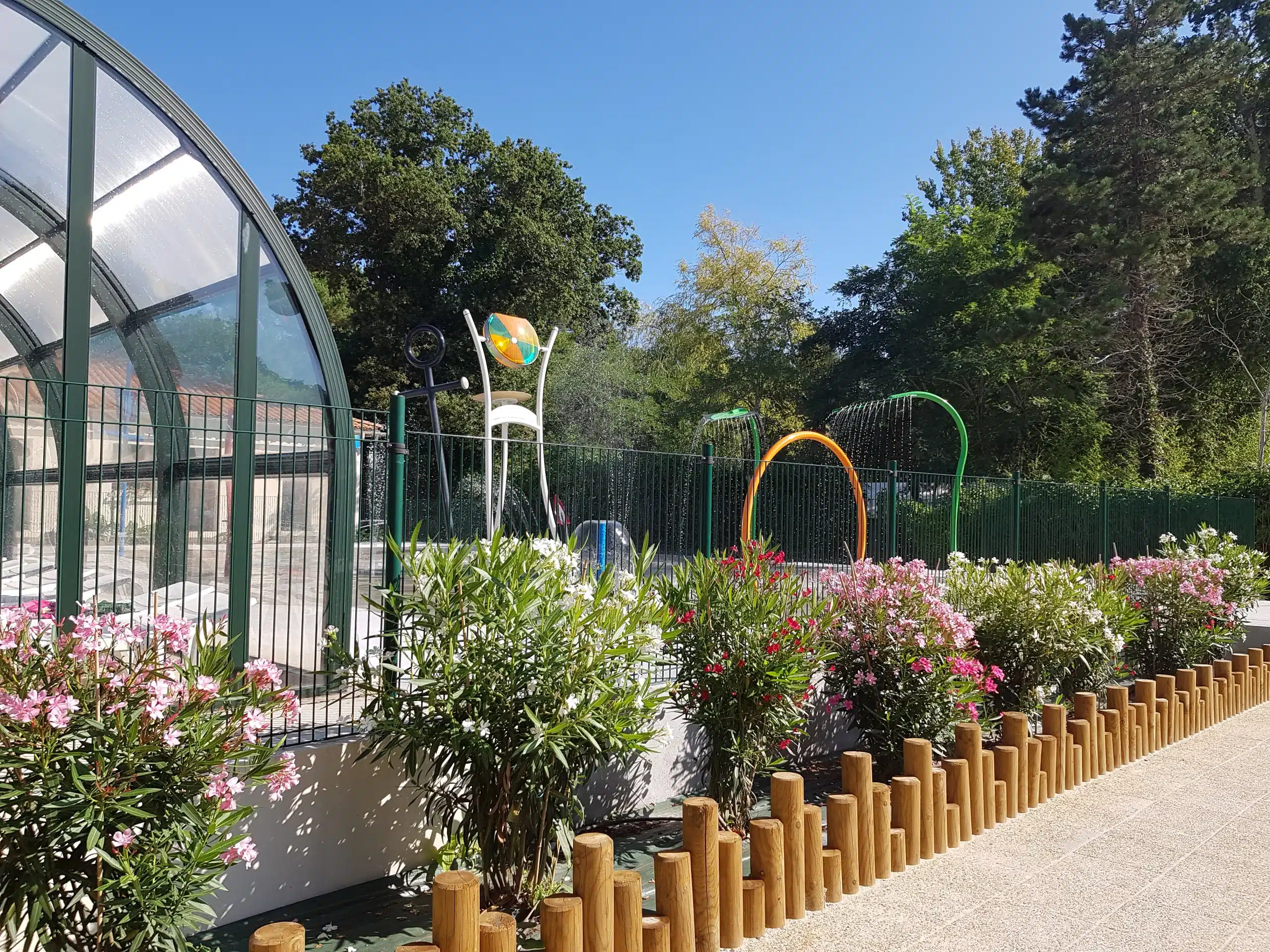 Aire de jeux aquatique en plein air, entourée d'arbres.