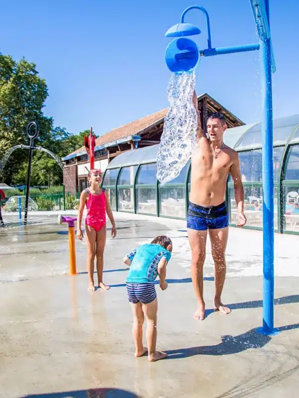Famille profitant des jeux d'eau au parc aquatique.