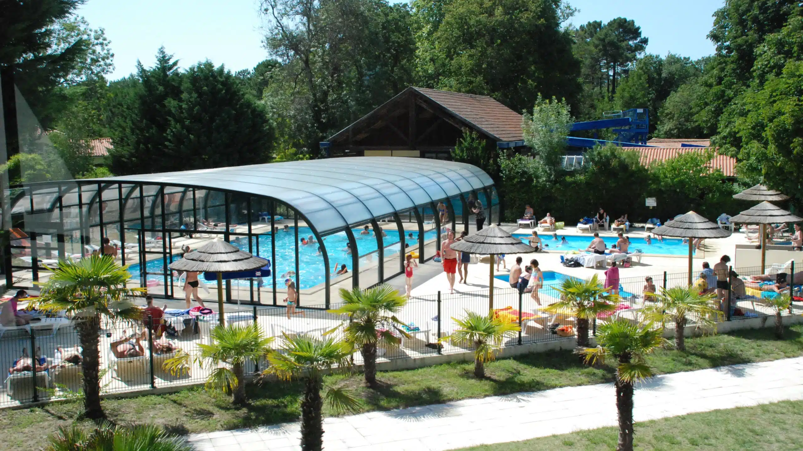Baignade estivale dans une piscine extérieure couverte.
