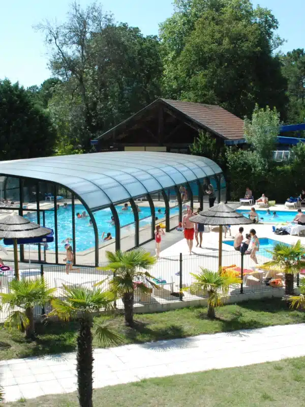 Baignade estivale dans une piscine extérieure couverte.
