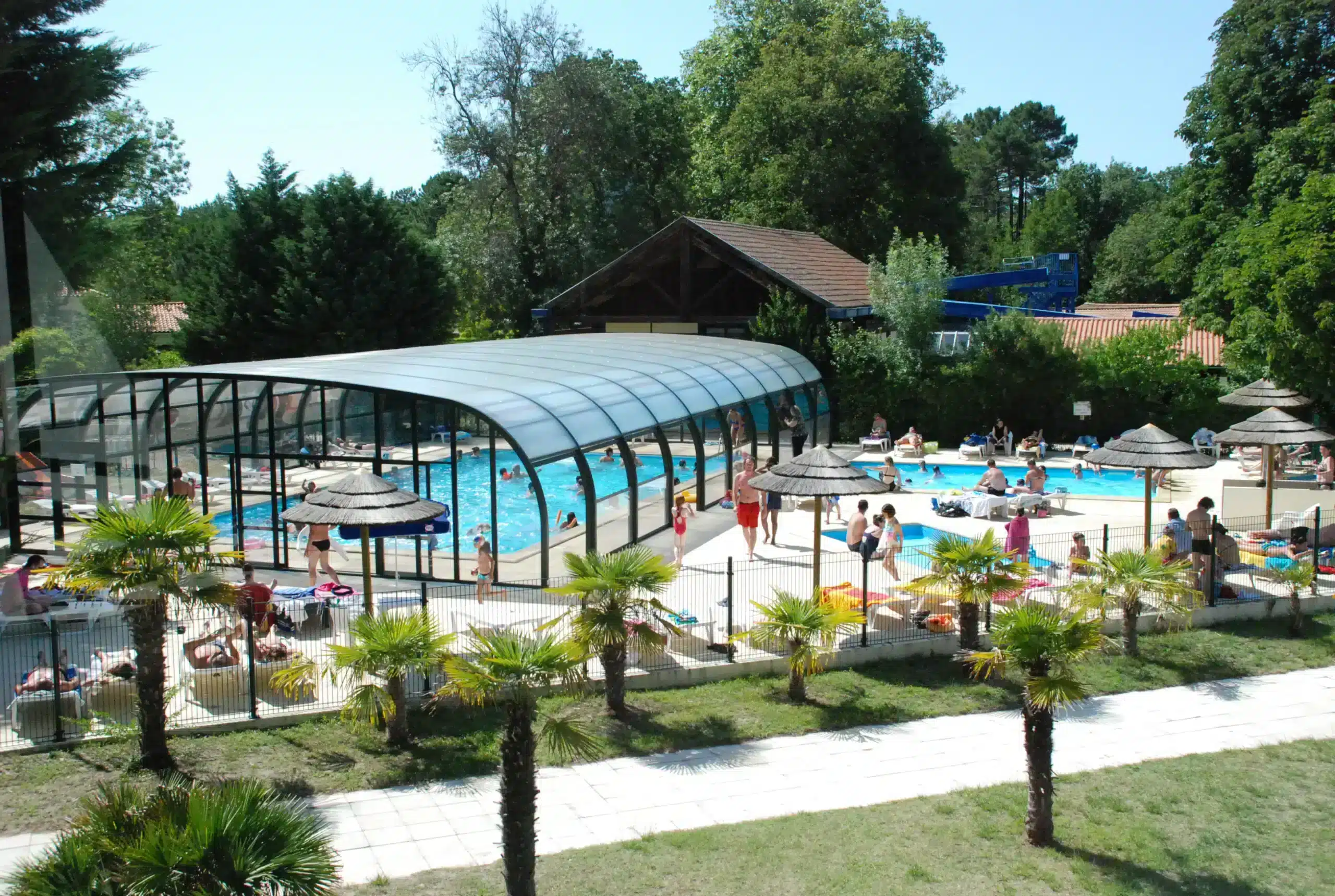 Baignade estivale dans une piscine extérieure couverte.