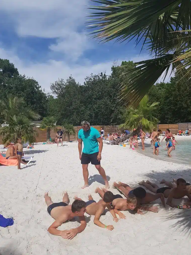 Groupe d'enfants allongés sur le sable à la plage.