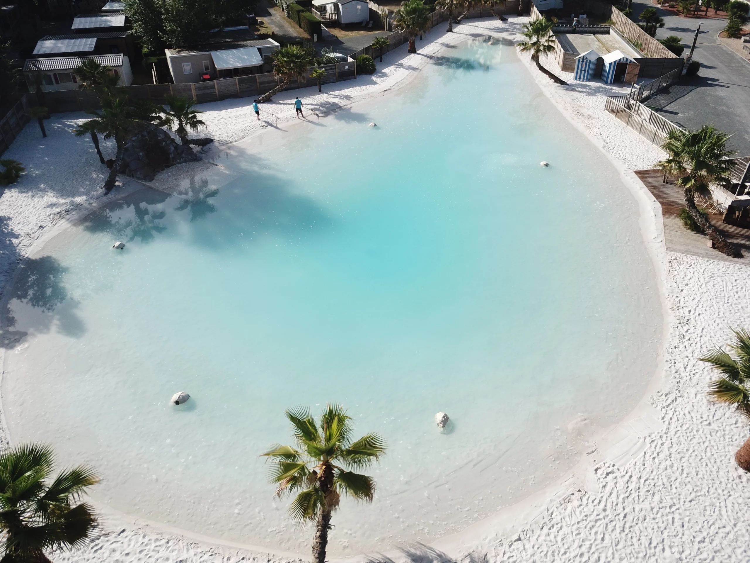 Lagon turquoise avec plage de sable blanc.