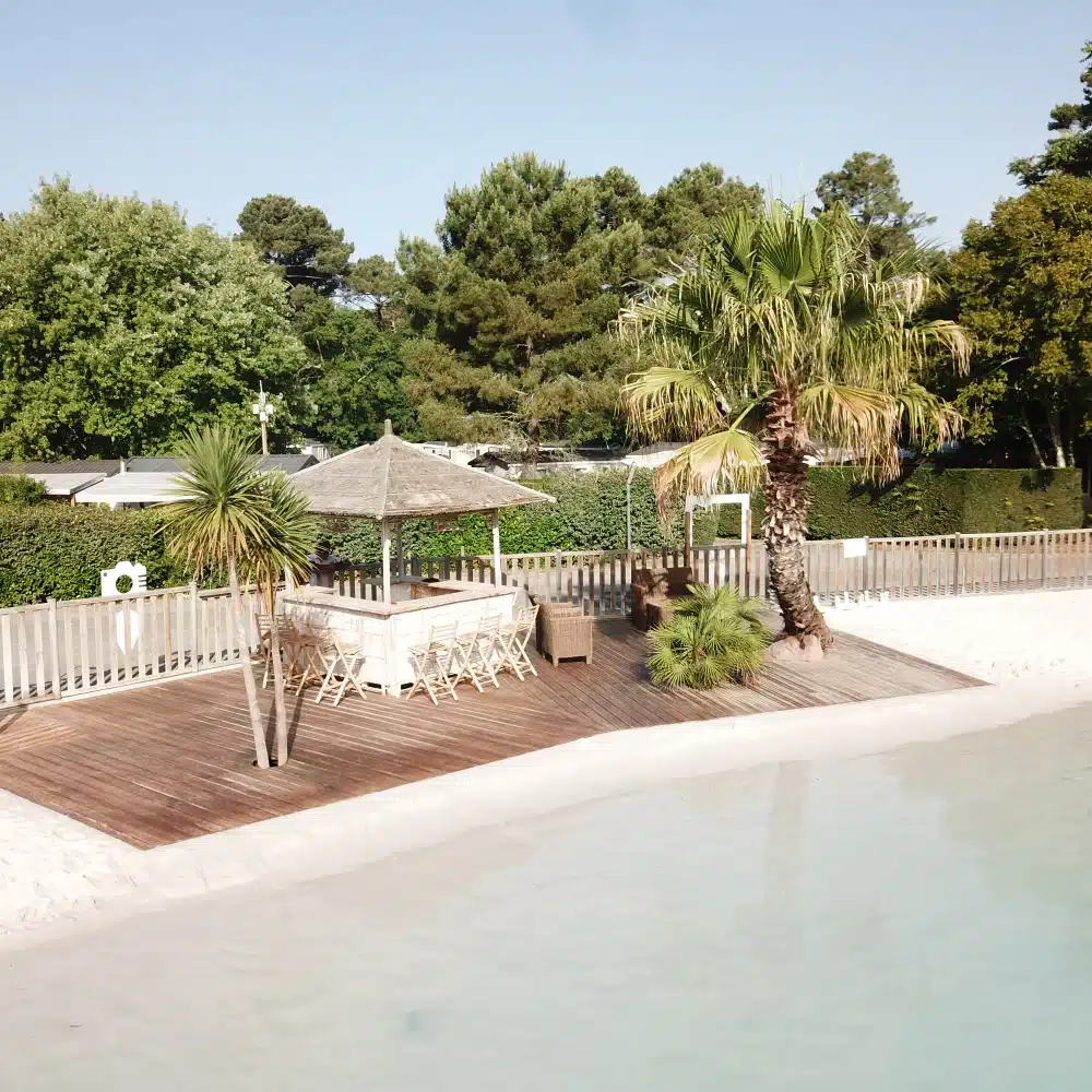 Piscine avec terrasse en bois et parasol.