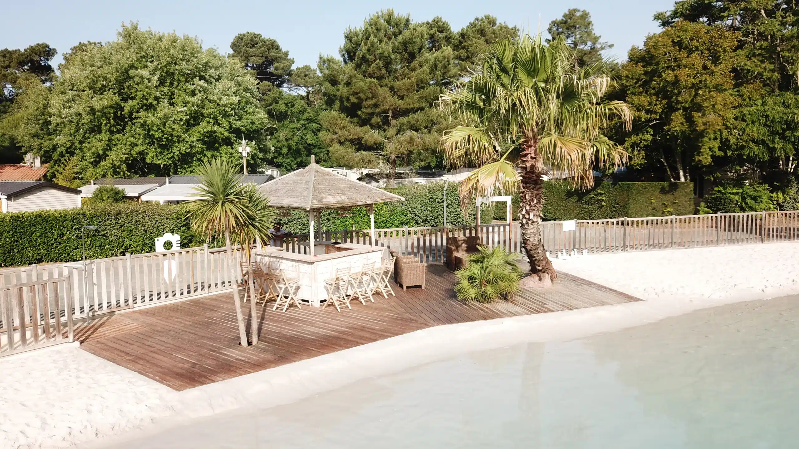 Piscine avec terrasse en bois et parasol.