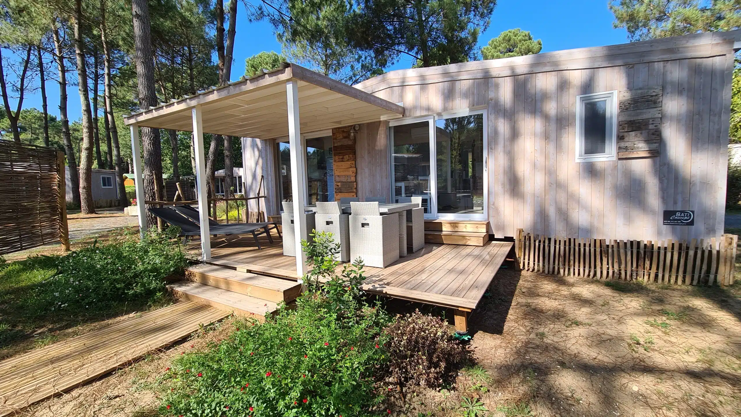 Chalet en bois dans une forêt ensoleillée.