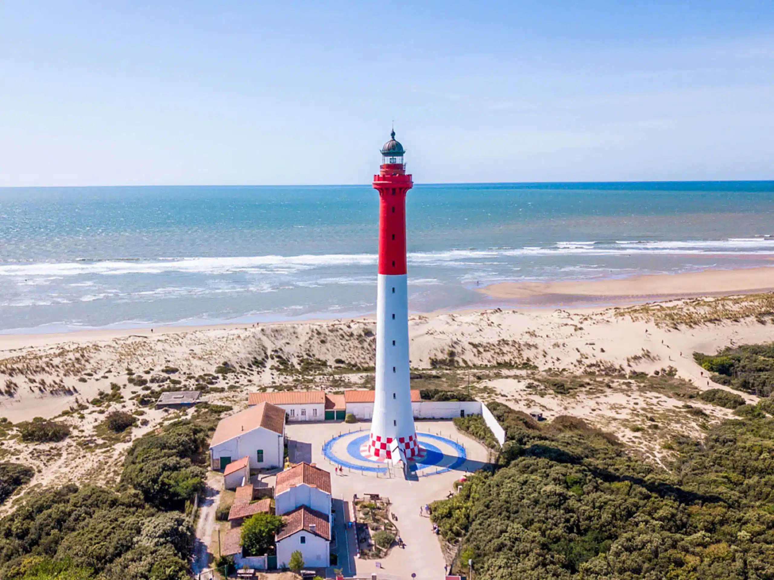 Phare blanc et rouge en bord de mer