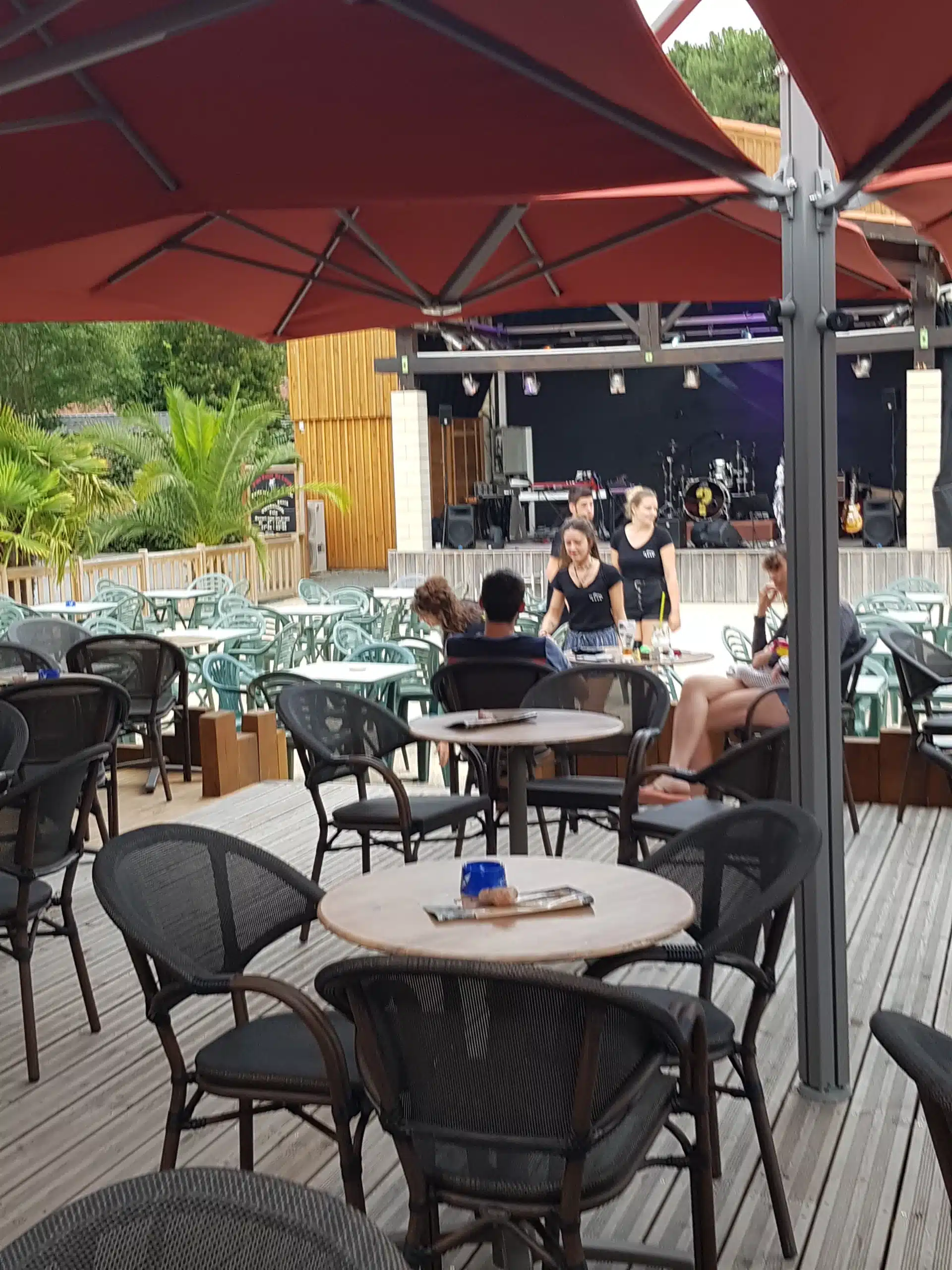 Terrasse de café avec scène musicale extérieure.