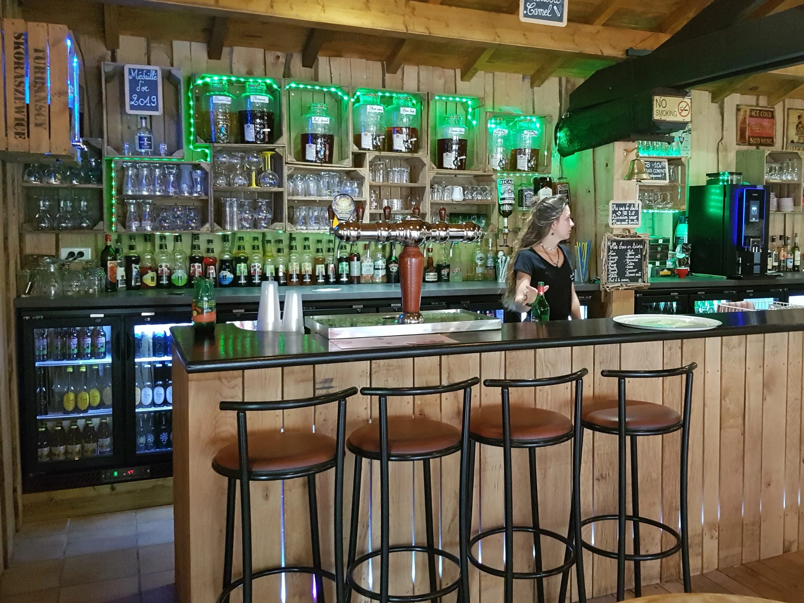 Bar rustique avec tabourets et boissons.