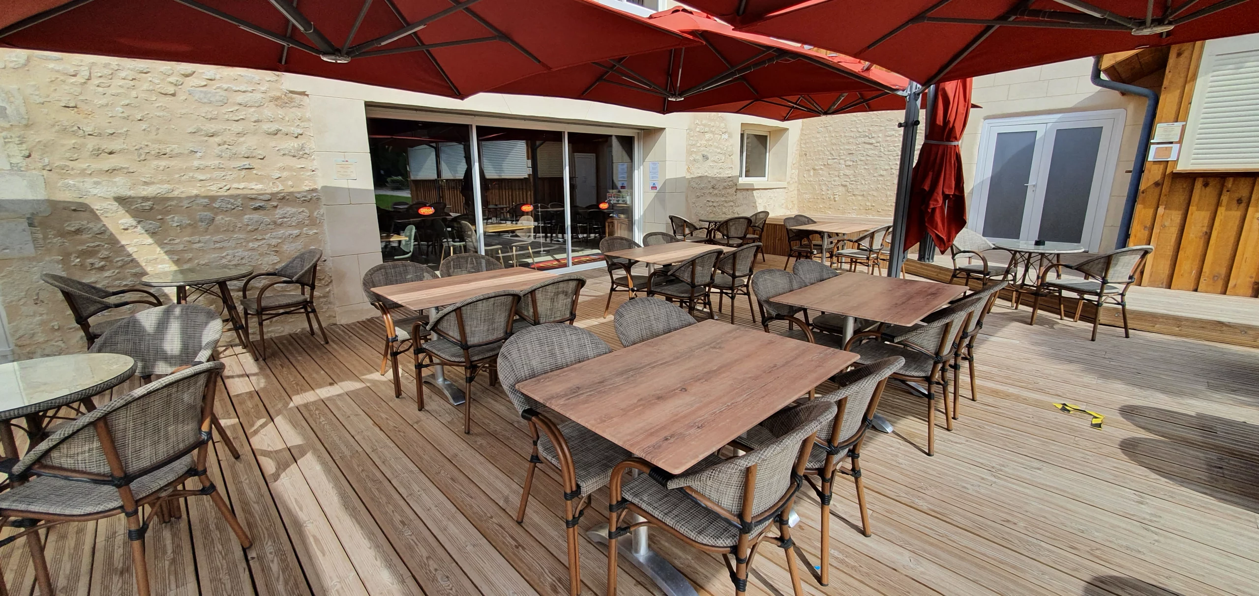 Terrasse de café avec tables et chaises extérieures.
