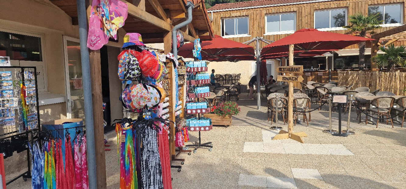 Terrasse de restaurant avec stands de vêtements colorés.