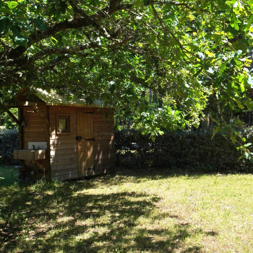 Cabane en bois dans un jardin ombragé