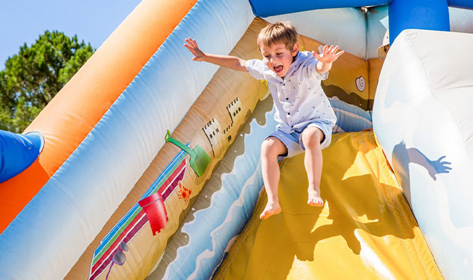 Enfant s'amusant sur le château gonflable du camping